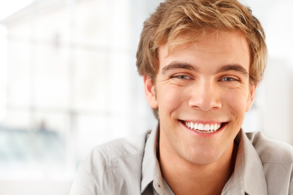 chico sonriendo en clínica de estética dental